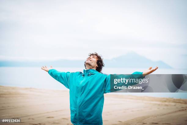 breathing exercise on the sea shore - mental wellbeing stock pictures, royalty-free photos & images