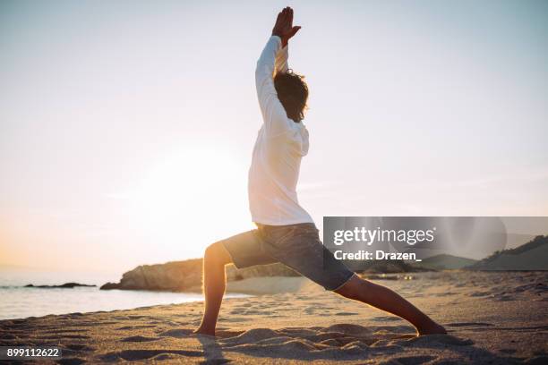 warrior pose on the beach in sunset - warrior position stock pictures, royalty-free photos & images