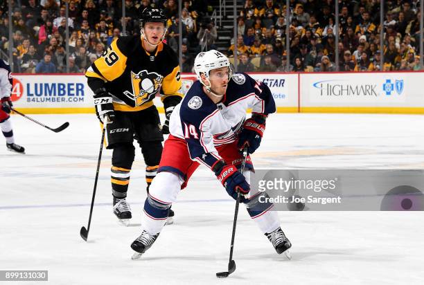 Jordan Schroeder of the Columbus Blue Jackets handles the puck against Jake Guentzel of the Pittsburgh Penguins at PPG Paints Arena on December 27,...