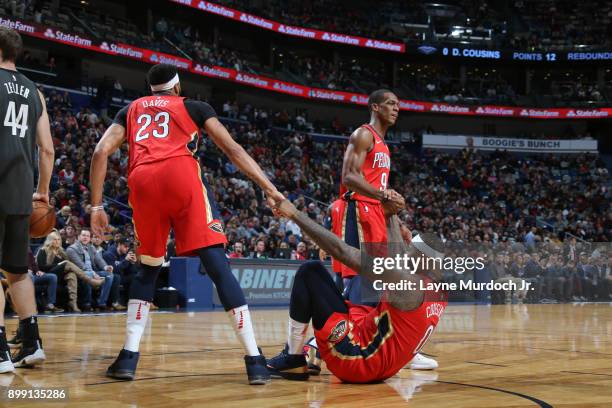 Anthony Davis and Rajon Rondo help up DeMarcus Cousins of the New Orleans Pelicans during the game against the Brooklyn Nets on December 27, 2017 at...