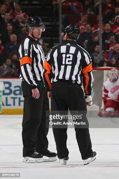 Referees Kevin Pollack and Justin StPierre look on during the game between the New Jersey Devils and Detroit Red Wings at Prudential Center on...