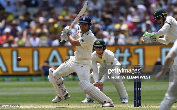 England's batsman Alastair Cook cuts a ball away as Australia's Cameron Bancroft and Tim Paine look on, on the third day of the fourth Ashes cricket...