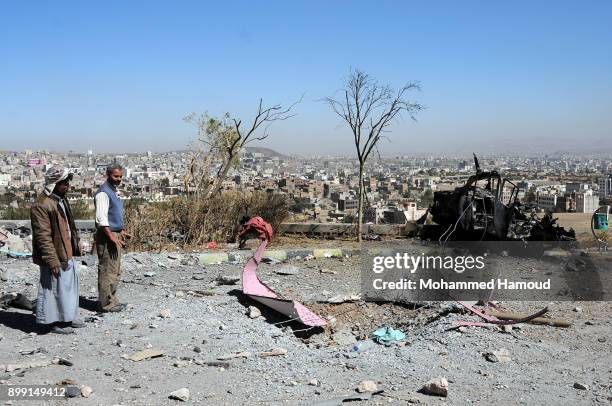 People walk on rubble as they inspects a house of 11-members from one family after it was hit by airstrikes carried out by the Saudi-led coalition on...