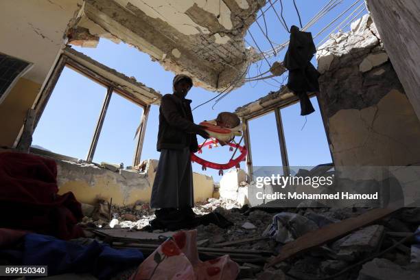 Man inspects a house of 11-members from one family after it was hit by airstrikes carried out by the Saudi-led coalition on Monday leaving the nine...