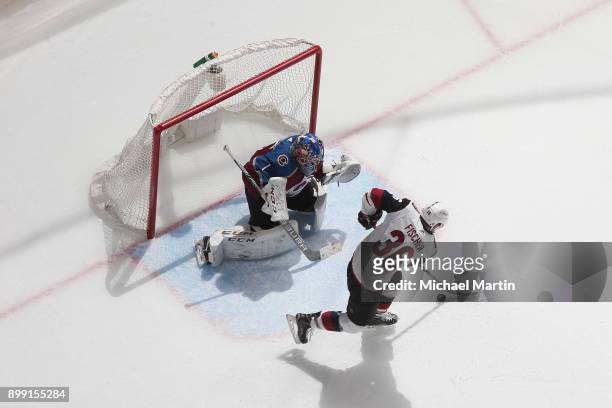 Christian Fischer of the Arizona Coyotes handles the puck infront of goaltender Semyon Varlamov of the Colorado Avalanche at the Pepsi Center on...