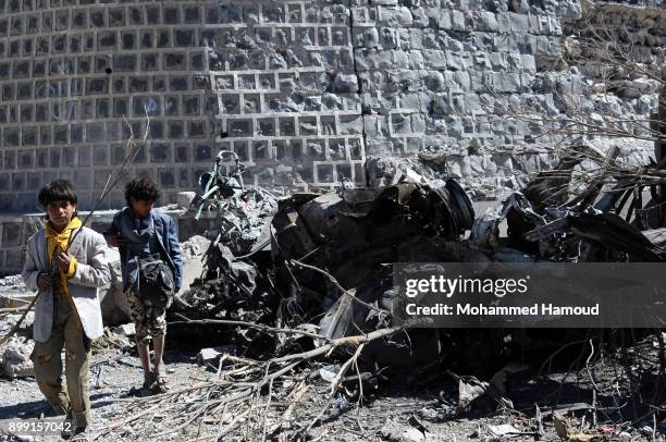 People walk on rubble as they inspects a house of 11-members from one family after it was hit by airstrikes carried out by the Saudi-led coalition on...