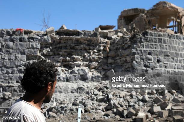 People walk on rubble as they inspects a house of 11-members from one family after it was hit by airstrikes carried out by the Saudi-led coalition on...