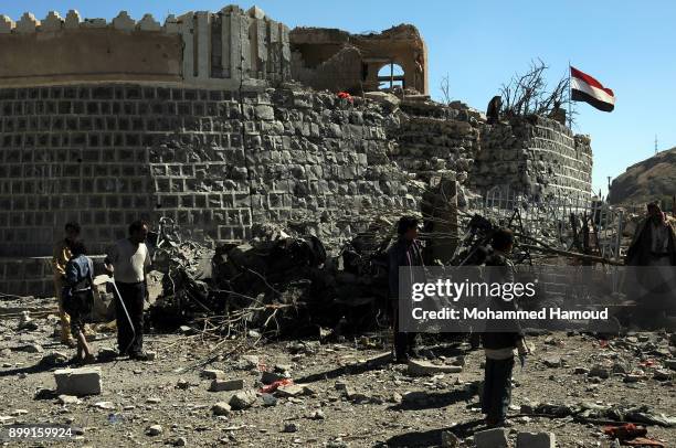 People walk on rubble as they inspects a house of 11-members from one family after it was hit by airstrikes carried out by the Saudi-led coalition on...