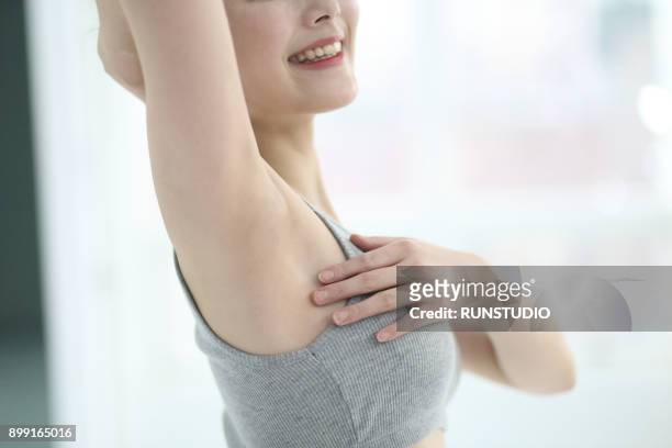 cropped image of woman touching armpit - seno foto e immagini stock