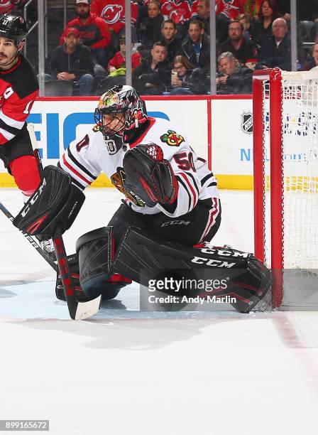 Corey Crawford of the Chicago Blackhawks defends his net against the New Jersey Devils at Prudential Center on December 23, 2017 in Newark, New...