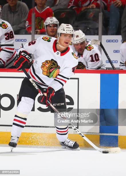 Gustav Forsling of the Chicago Blackhawks plays the puck against the New Jersey Devils at Prudential Center on December 23, 2017 in Newark, New...