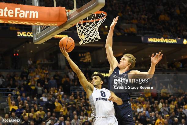 Markus Howard of the Marquette Golden Eagles drives to the basket against J.P. Macura of the Xavier Musketeers during the second half at the BMO...