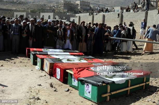 People pray on coffins of members from one family after they were killed by airstrikes carried out by the Saudi-led coalition hit their house on...