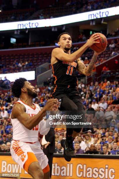 Florida Gators guard Chris Chiozza attempts a layup as Clemson Tigers guard Gabe DeVoe defends during the first half of the MetroPCS Orange Bowl...