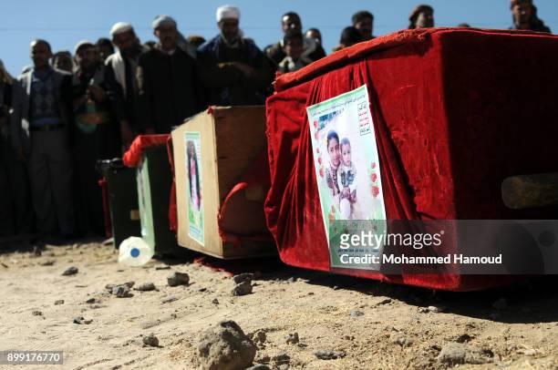 People pray on coffins of members from one family after they were killed by airstrikes carried out by the Saudi-led coalition hit their house on...