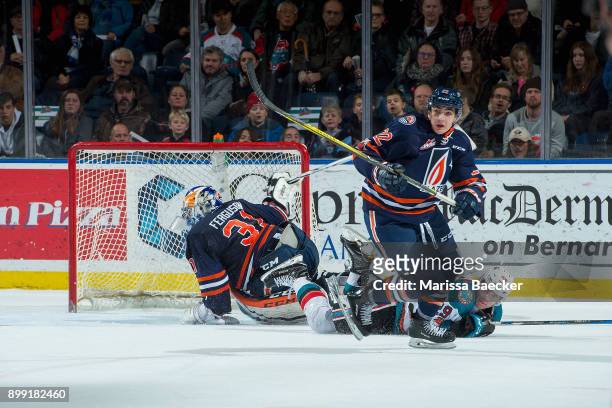 Nolan Foote of the Kelowna Rockets falls to the ice after a check by Quinn Benjafield into the net of Dylan Ferguson of the Kamloops Blazers during...