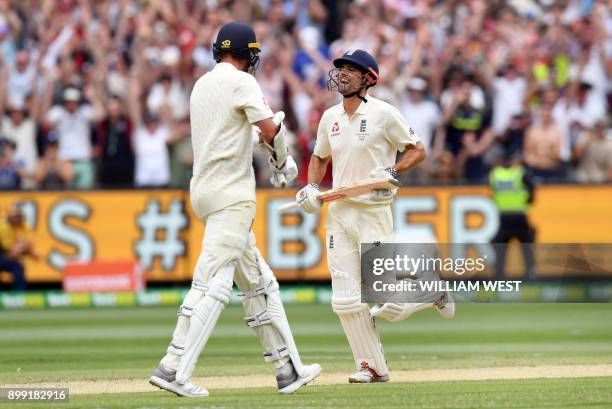 England's batsman Alastair Cook celebrates scoring his double century against Australia with teammate Stuart Broad on the third day of the fourth...