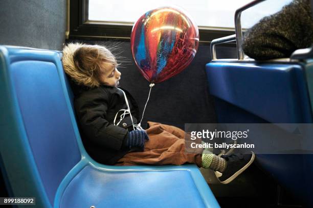 Boy Asleep On Bus With Balloon