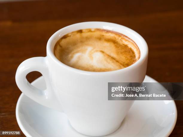 cup of coffee espresso in a cup of white porcelain  on a table of wood illuminated by the light of the sun outdoors. spain. - artificial sweeteners stock pictures, royalty-free photos & images