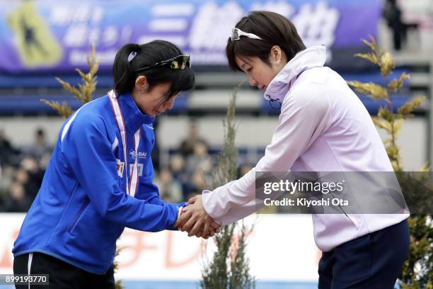 Winner Nao Kodaira shakes hands with runner-up Miho Takagi at the award ceremony for the Ladies' 1000m competition during day two of the Speed...