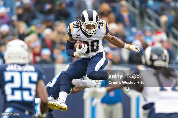 Todd Gurley II of the Los Angeles Rams jumps over Brice McCain of the Tennessee Titans at Nissan Stadium on December 24, 2017 in Nashville,...