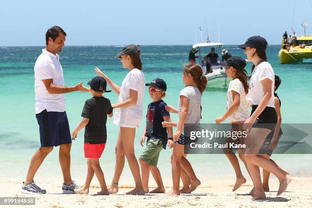 Roger Federer of Switzerland is greeted on the beach by children after arriving at Rottnest Island ahead of the 2018 Hopman Cup on December 28, 2017...