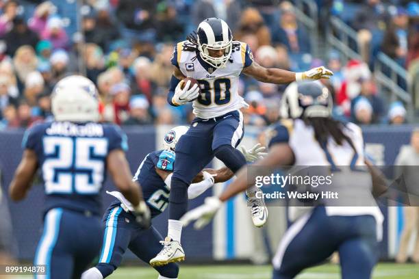 Todd Gurley II of the Los Angeles Rams jumps over Brice McCain of the Tennessee Titans at Nissan Stadium on December 24, 2017 in Nashville,...