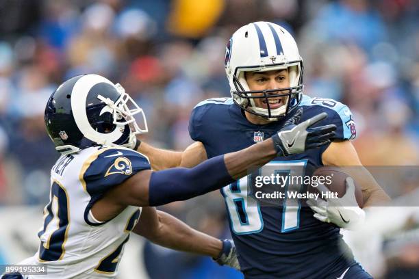 Eric Decker of the Tennessee Titans gives a stiff arm to Lamarcus Joyner of the Los Angeles Rams at Nissan Stadium on December 24, 2017 in Nashville,...