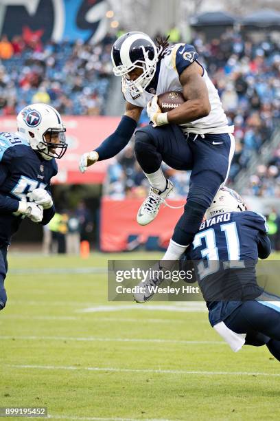 Todd Gurley II of the Los Angeles Rams jumps over Kevin Byard and is hit by Wesley Woodyard of the Tennessee Titans at Nissan Stadium on December 24,...