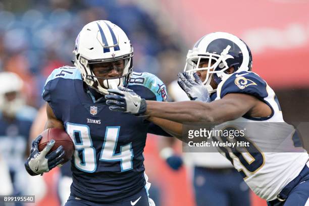 Corey Davis of the Tennessee Titans runs the ball and tries to avoid the tackle of Lamarcus Joyner of the Los Angeles Rams at Nissan Stadium on...