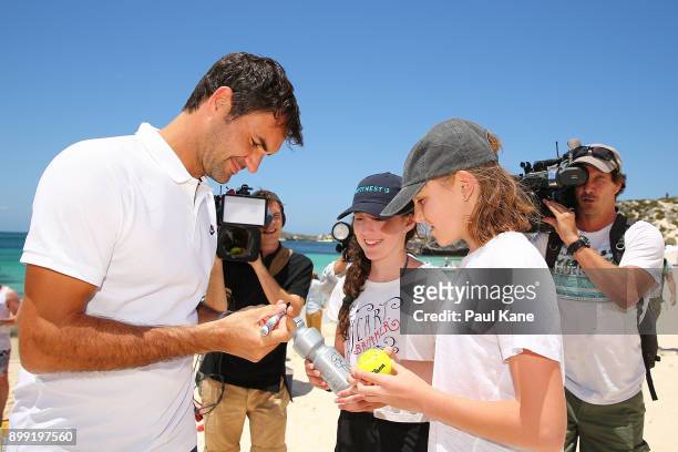 Roger Federer of Switzerland signs autographs on the beach for children at Rottnest Island ahead of the 2018 Hopman Cup on December 28, 2017 in...