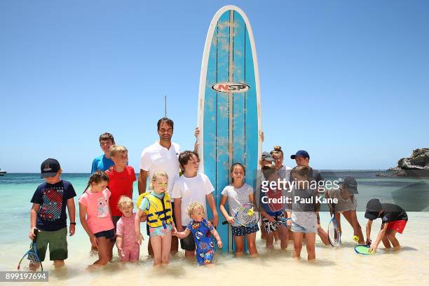 Roger Federer of Switzerland poses with a stand up paddle board and children at Rottnest Island ahead of the 2018 Hopman Cup on December 28, 2017 in...
