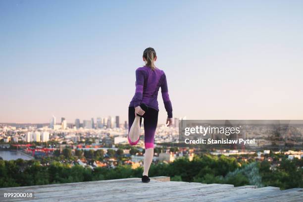 female runner stretching, paris in background - paris sport stock pictures, royalty-free photos & images