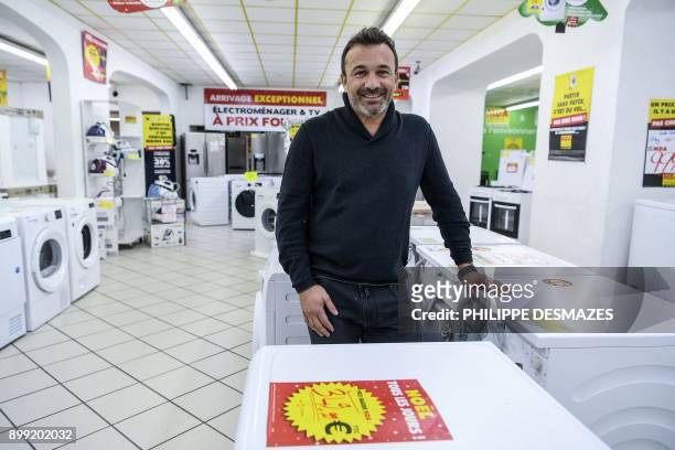 Michel Vieira, CEO of the MDA Domestic electrical goods, poses for photographs inside one of his stores on December 21, 2017 in Lozanne near Lyon,...
