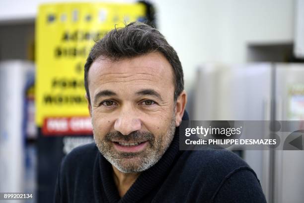 Michel Vieira, CEO of the MDA Domestic electrical goods, poses for photographs inside one of his stores on December 21, 2017 in Lozanne near Lyon,...