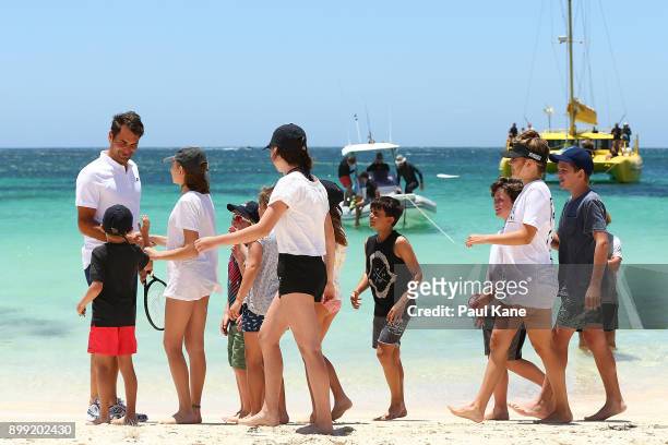 Roger Federer of Switzerland is greeted on the beach by children after arriving at Rottnest Island ahead of the 2018 Hopman Cup on December 28, 2017...