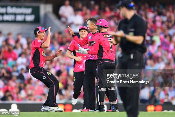 Johan Botha of the Sixers celebrates with team mates after taking the wicket of Travis Head of the Strikers during the Big Bash League match between...