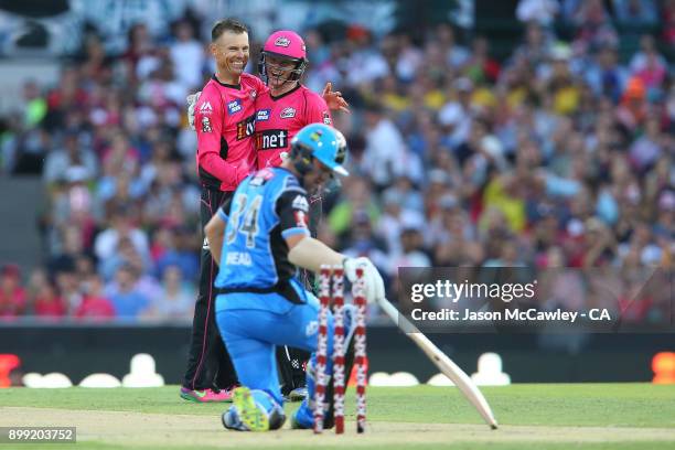 Johan Botha and Sam Billings of the Sixers celebrate after dismissing Travis Head of the Strikers during the Big Bash League match between the Sydney...