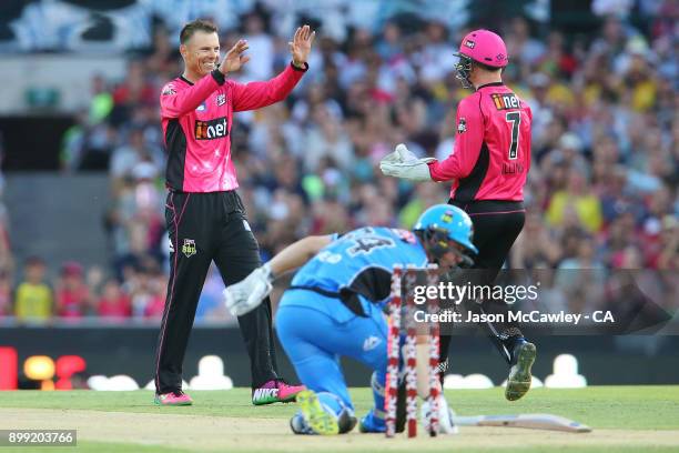 Johan Botha and Sam Billings of the Sixers celebrate after dismissing Travis Head of the Strikers during the Big Bash League match between the Sydney...