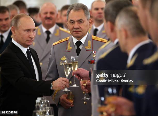 Russian President Vladimir Putin and Defence Minister Sergey Shoigu toast during a reception for military servicemen who took part in Syrian...