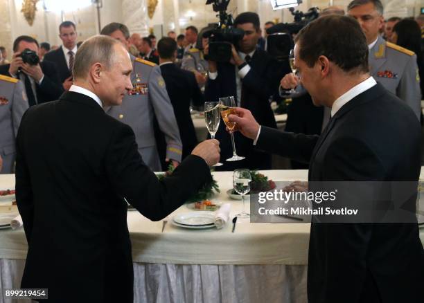 Russian President Vladimir Putin toasts with Prime Minister Dmitry Medvedev at a reception for military servicemen who took part in Syrian campaign,...