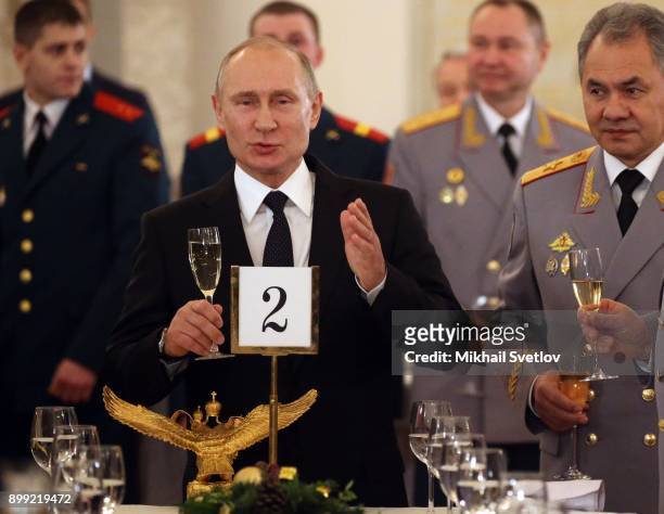 Russian President Vladimir Putin toasts with Defence Minister Sergey Shoigu at a reception for military servicemen who took part in Syrian campaign,...