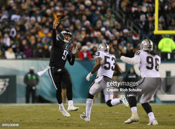 Quarterback Nick Foles of the Philadelphia Eagles attempts a pass as NaVorro Bowman and Derek Barnett of the Oakland Raiders defend during a game at...