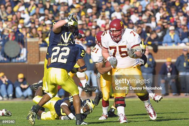 Offensive lineman Jake Kuppe of the Minnesota Golden Gophers sets his sights on steamrolling safety Jon Shaw of the Michigan Wolverines during the...
