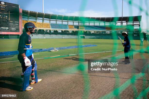 Sri Lanka cricket's new head coach Chandika Hathurusingha demonstrates batting techniques as Sri Lankan cricket captain Dinesh Chandimal looks on at...