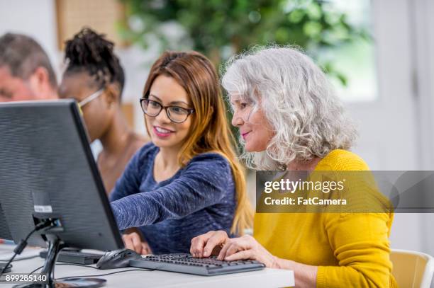 コンピューターを使用して女性を助ける - 社会人学生 ストックフォトと画像