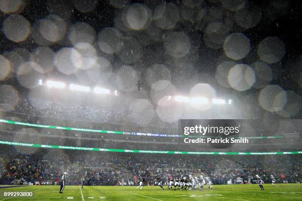 Heavy rain falls as Quarterback Joe Flacco hands the ball off to running back Alex Collins of the Baltimore Ravens against the Indianapolis Colts in...
