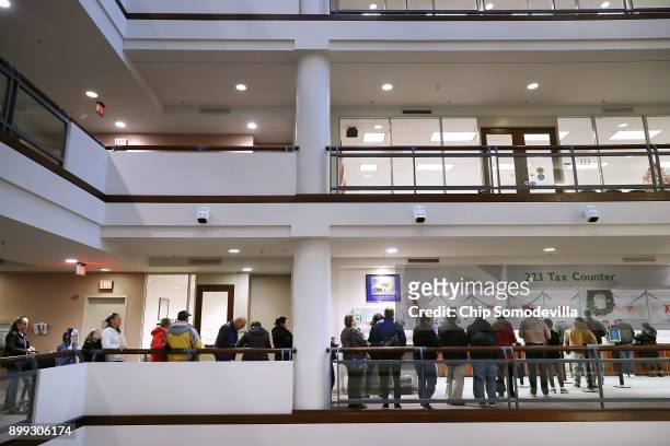 Residents wait in line to pay taxes at the Fairfax County Government Center December 28, 2017 in Fairfax, Virginia. Many people are pre-paying their...