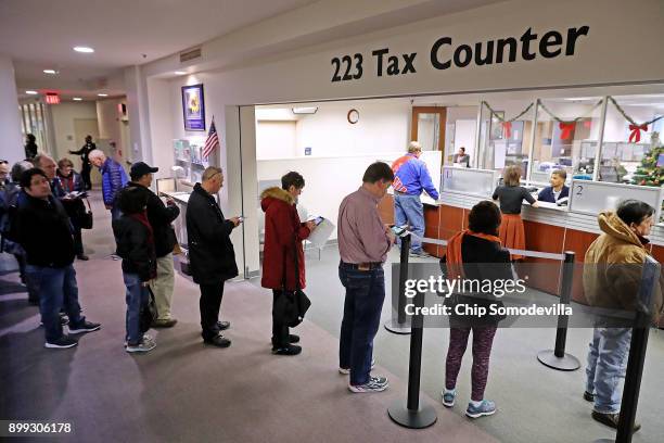 Residents wait in line to pay taxes at the Fairfax County Government Center December 28, 2017 in Fairfax, Virginia. Many people are pre-paying their...