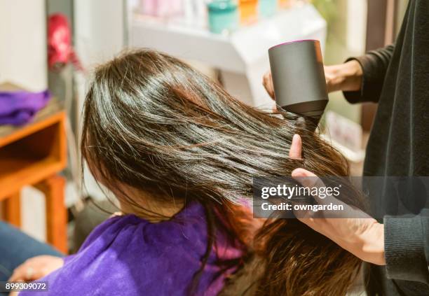 woman getting her hair styled at hairdressers - hand holding hair dryer stock pictures, royalty-free photos & images